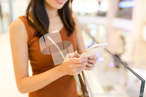 Image of Woman use of cellphone at shopping mall