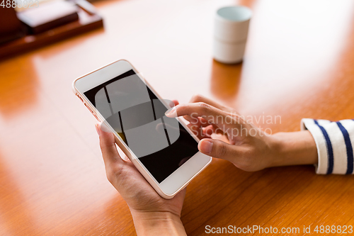 Image of Finger using cellphone in restaurant