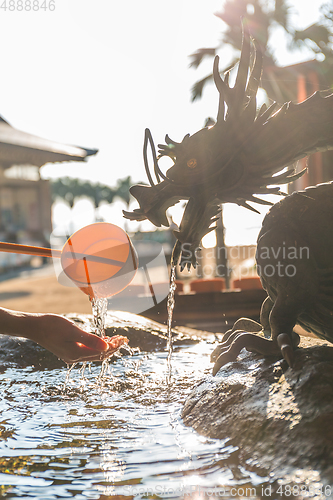 Image of Bamboo water fountain with dragon statue under sunlight