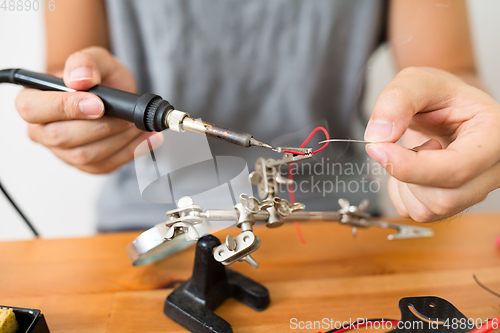 Image of Man welding parts on drone body