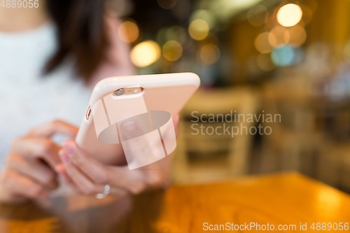 Image of Woman use of mobile phone in coffee shop