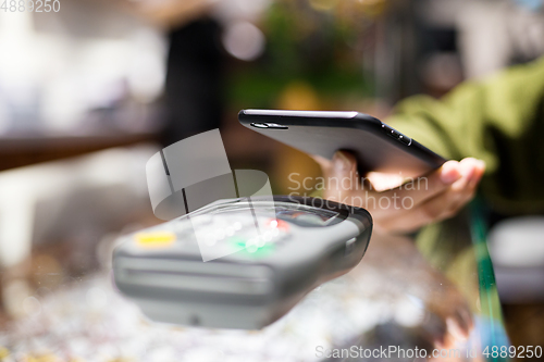 Image of Woman paying with smartphone by NFC