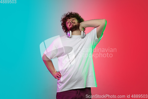 Image of Caucasian young man\'s portrait on gradient studio background in neon