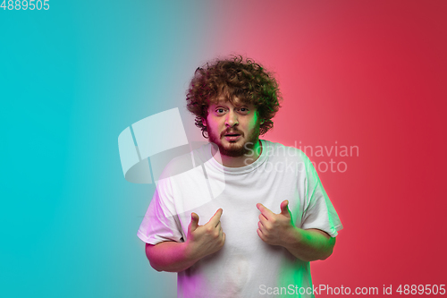 Image of Caucasian young man\'s portrait on gradient studio background in neon