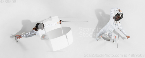 Image of Teen girl in fencing costume with sword in hand isolated on white background, top view