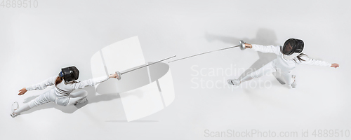 Image of Teen girl in fencing costume with sword in hand isolated on white background, top view