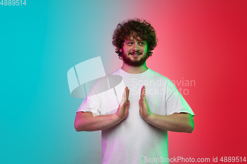Image of Caucasian young man\'s portrait on gradient studio background in neon