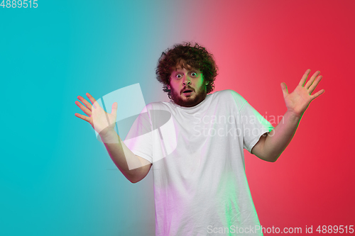 Image of Caucasian young man\'s portrait on gradient studio background in neon