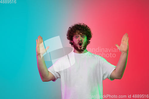 Image of Caucasian young man\'s portrait on gradient studio background in neon