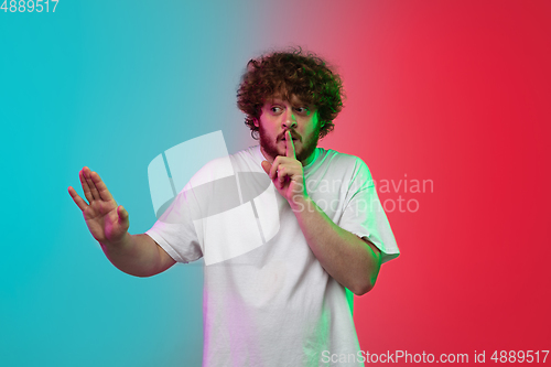 Image of Caucasian young man\'s portrait on gradient studio background in neon