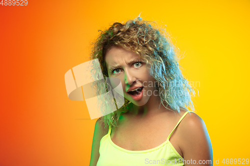 Image of Caucasian young woman\'s portrait on gradient studio background in neon