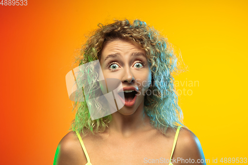 Image of Caucasian young woman\'s portrait on gradient studio background in neon