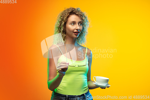Image of Caucasian young woman\'s portrait on gradient studio background in neon