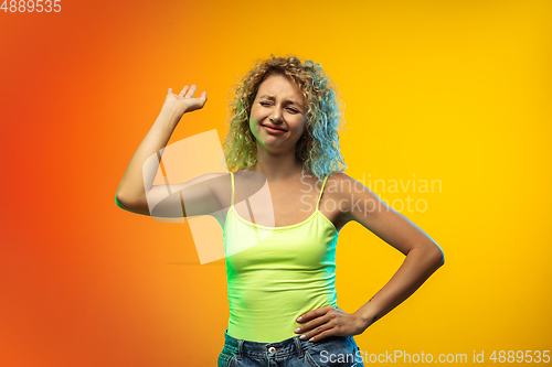 Image of Caucasian young woman\'s portrait on gradient studio background in neon