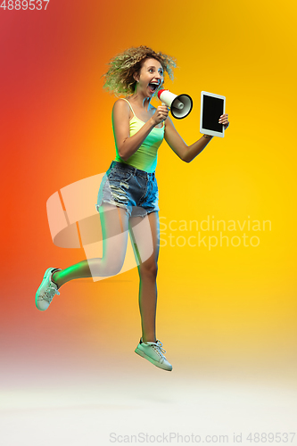 Image of Caucasian young woman\'s portrait on gradient studio background in neon