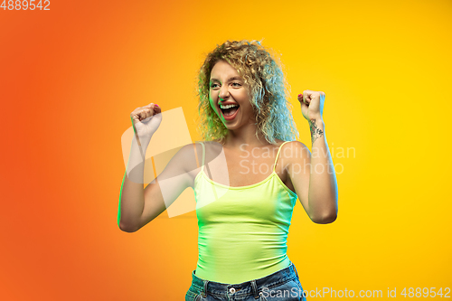 Image of Caucasian young woman\'s portrait on gradient studio background in neon
