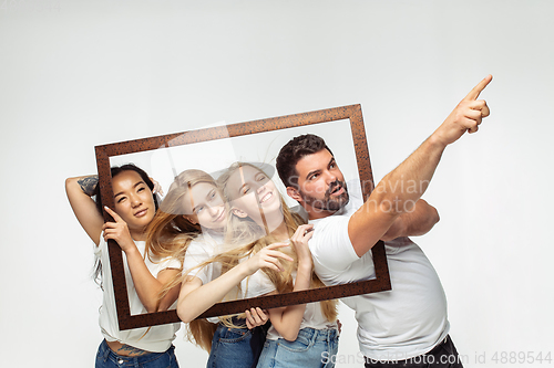 Image of Group of adorable multiethnic friends having fun isolated over white studio background