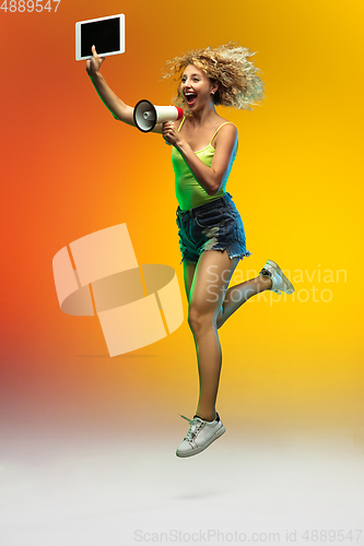 Image of Caucasian young woman\'s portrait on gradient studio background in neon
