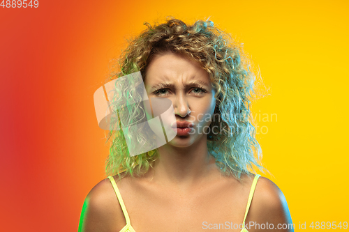 Image of Caucasian young woman\'s portrait on gradient studio background in neon