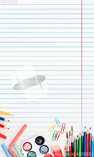 Image of Colorful school supplies corner border over a lined paper background with negative space