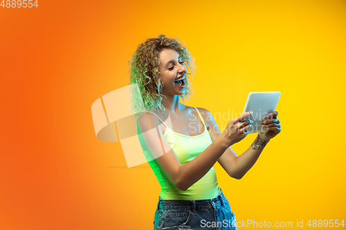Image of Caucasian young woman\'s portrait on gradient studio background in neon