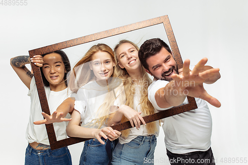 Image of Group of adorable multiethnic friends having fun isolated over white studio background