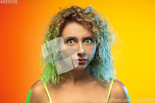 Image of Caucasian young woman\'s portrait on gradient studio background in neon
