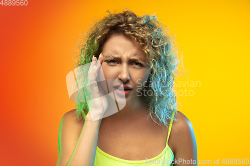 Image of Caucasian young woman\'s portrait on gradient studio background in neon