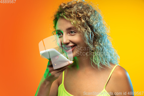 Image of Caucasian young woman\'s portrait on gradient studio background in neon