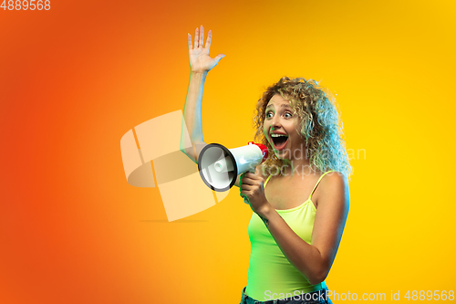 Image of Caucasian young woman\'s portrait on gradient studio background in neon