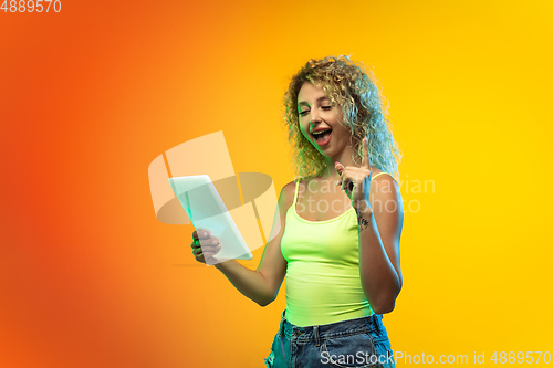 Image of Caucasian young woman\'s portrait on gradient studio background in neon