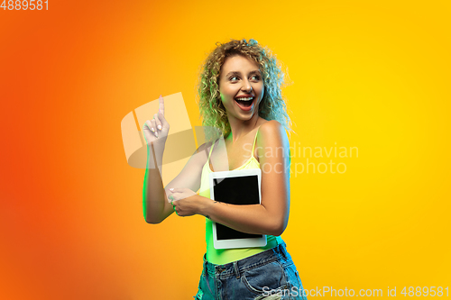 Image of Caucasian young woman\'s portrait on gradient studio background in neon
