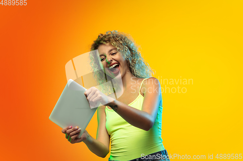Image of Caucasian young woman\'s portrait on gradient studio background in neon