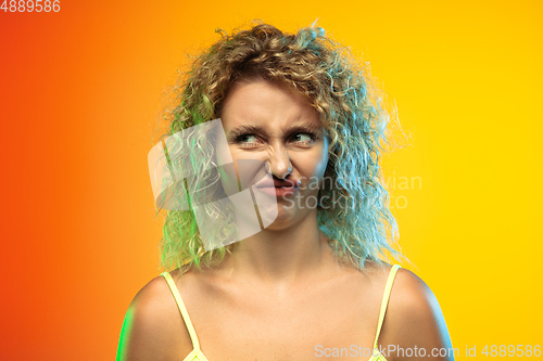Image of Caucasian young woman\'s portrait on gradient studio background in neon