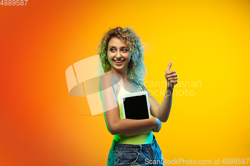 Image of Caucasian young woman\'s portrait on gradient studio background in neon