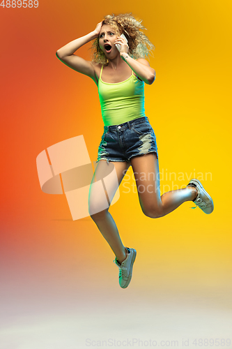 Image of Caucasian young woman\'s portrait on gradient studio background in neon