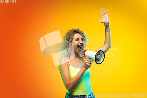 Image of Caucasian young woman\'s portrait on gradient studio background in neon