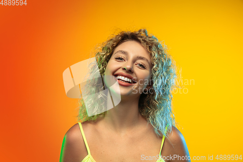 Image of Caucasian young woman\'s portrait on gradient studio background in neon