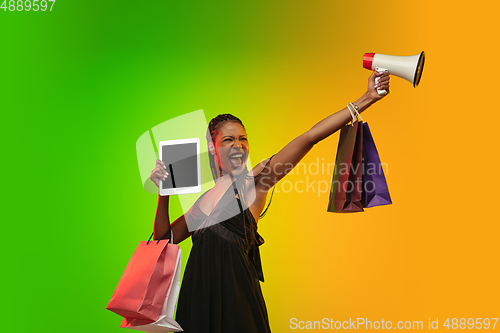 Image of Portrait of young woman in neon light on gradient backgound. The human emotions, black friday, cyber monday, purchases, sales, finance concept.