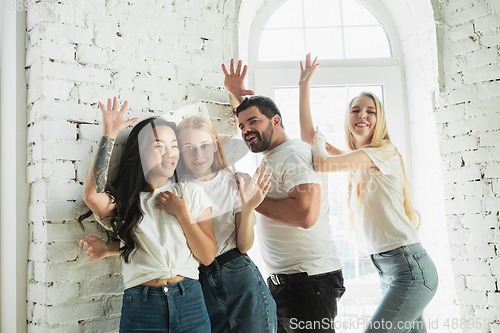 Image of Group of adorable multiethnic friends having fun at home interior background