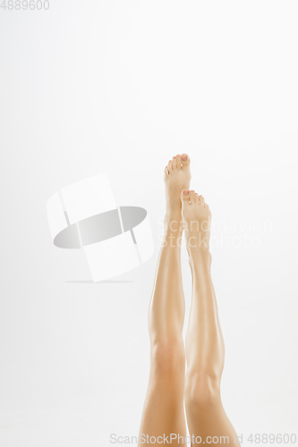 Image of Beautiful female legs isolated on white background. Beauty, cosmetics, spa, depilation, treatment and fitness concept.