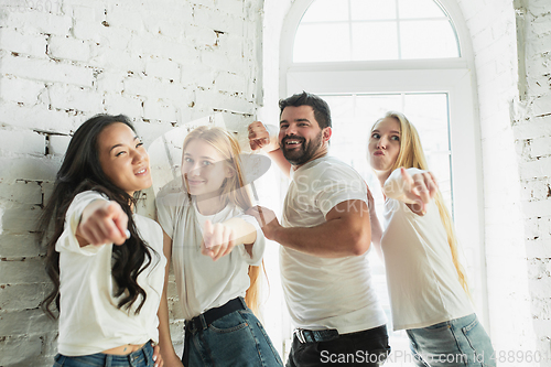 Image of Group of adorable multiethnic friends having fun at home interior background