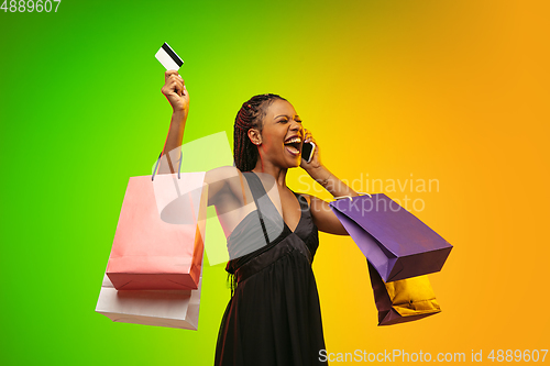 Image of Portrait of young woman in neon light on gradient backgound. The human emotions, black friday, cyber monday, purchases, sales, finance concept.