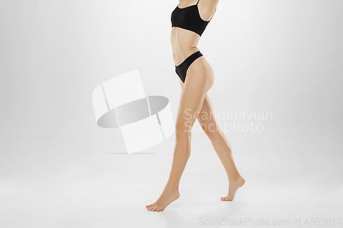 Image of Beautiful female legs and belly isolated on white background. Beauty, cosmetics, spa, depilation, treatment and fitness concept.