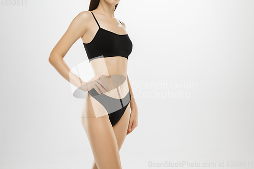 Image of Beautiful female legs and belly isolated on white background. Beauty, cosmetics, spa, depilation, treatment and fitness concept.