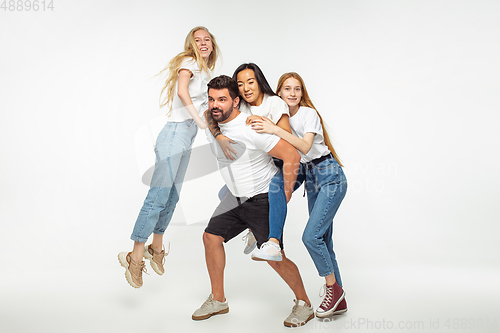 Image of Group of adorable multiethnic friends having fun isolated over white studio background