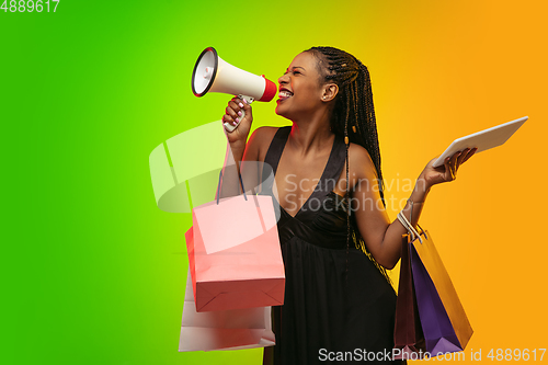 Image of Portrait of young woman in neon light on gradient backgound. The human emotions, black friday, cyber monday, purchases, sales, finance concept.