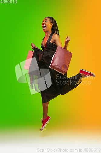 Image of Portrait of young woman in neon light on gradient backgound. The human emotions, black friday, cyber monday, purchases, sales, finance concept.