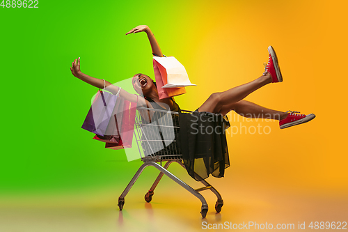 Image of Portrait of young woman in neon light on gradient backgound. The human emotions, black friday, cyber monday, purchases, sales, finance concept.