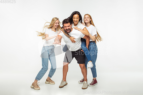 Image of Group of adorable multiethnic friends having fun isolated over white studio background